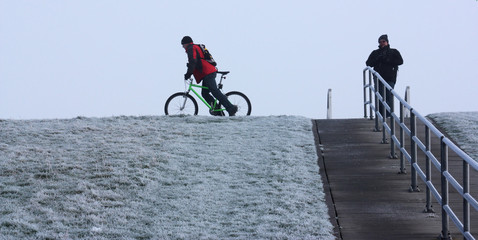 männer auf dem winterlichen deich