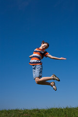 Girl running, jumping against blue sky