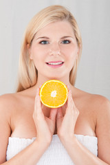 Young healthy woman with pure skin and citrus orange fruit