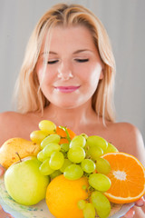 Young healthy woman with pure skin and fruits