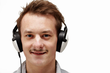 Handsome young man listening to music on white