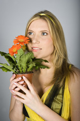 Young  sexy summer woman with orange daisy flowers in pot