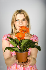Young  sexy summer woman with orange daisy flowers in pot