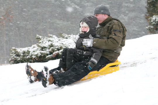 Winter fun - boy sledding with his father
