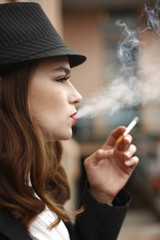 Obraz premium young and stylish woman smoking a cigarette