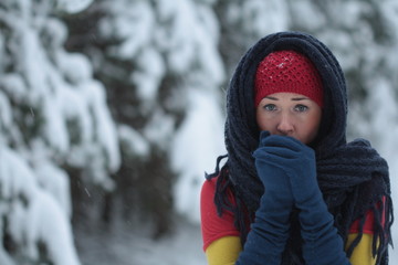 Young woman blow on her hands on the snow