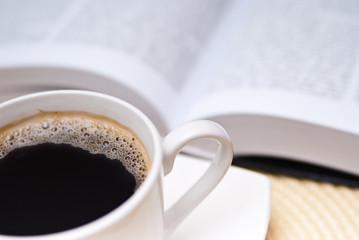cup of coffe and opened book