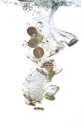 Euro coins falling into the clear water