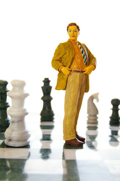 business man figure standing on a chess board