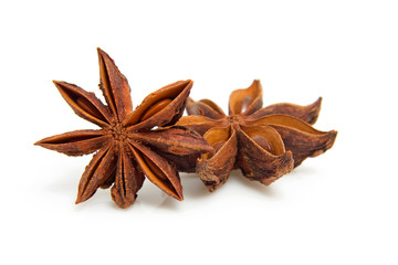 two star anise in closeup over white background