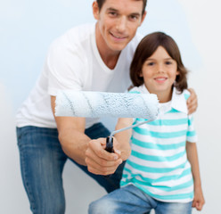 Father and his son holding a paintbrush