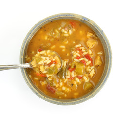 Vegetable soup with spoon in old bowl