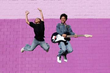 african american kids jumping with guitar