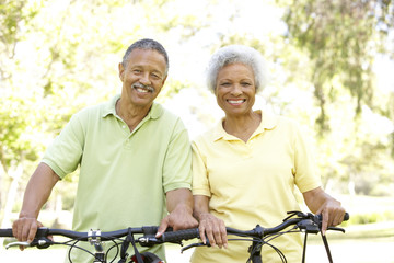 Obraz premium Senior Couple Riding Bikes In Park