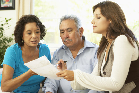 Senior Couple With Financial Advisor At Home