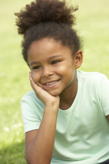 Portrait Of Young Girl Sitting In Park