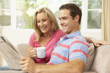 Couple Reading Newspaper At Home