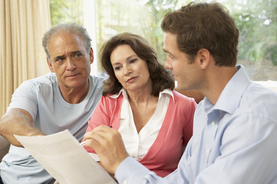 Senior Couple With Financial Advisor At Home