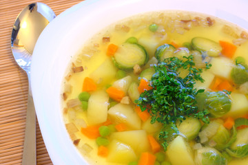 Portion of a summer vegetable soup with brussels and pea