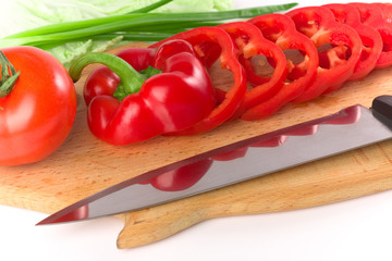 Sliced red ripe fresh pepper on cutting board with knife
