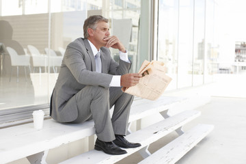Mature businessman reading a newspaper