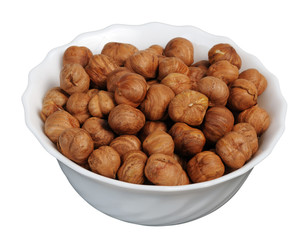 Hazelnuts on a white plate, isolated.