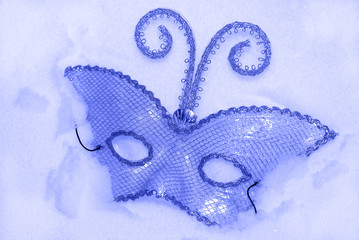 Lost carnival mask in snow blue tinted