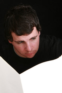 Young Man Reading A Blank Newspaper