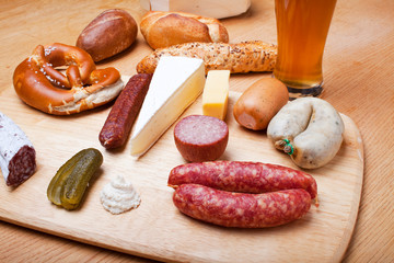 Wurst, Brot und ein Weißbier auf einem Eichentisch