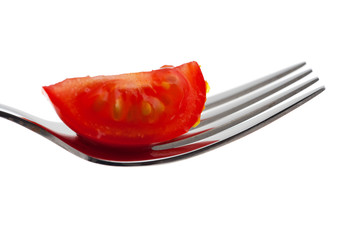 Scheibe einer Tomate auf einer Gabel isoliert auf Weiß