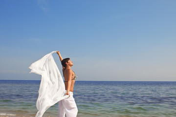 Fototapeta na wymiar happy woman with a scarf on the beach