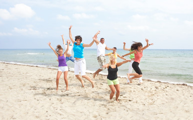 happy crew jumping on the beach
