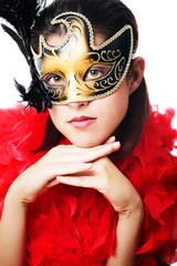 Beautiful young woman in carnival mask and feather boa