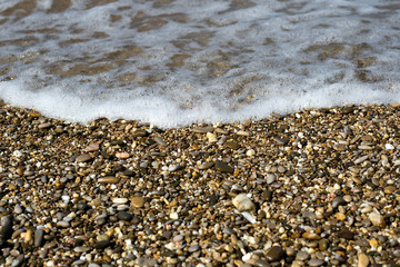 Pebbles on beach with sea wave