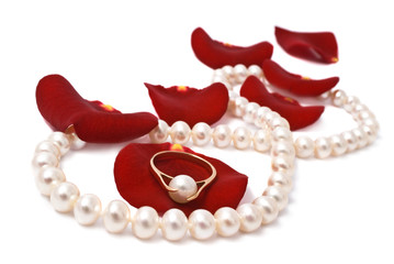 Pearl necklace on red petals