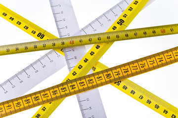 tape measures cross on white background