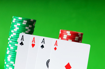 Casino chips and cards against green background