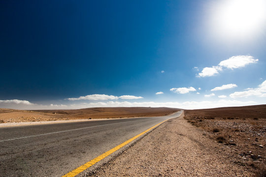 Empty desert road with blue sky.