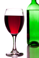 glass of red wine and green bottle
