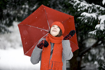 Frau im Schnee mit rotem Schirm