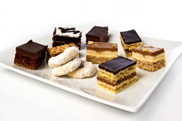 lots of cakes and cookies on a plate isolated on white