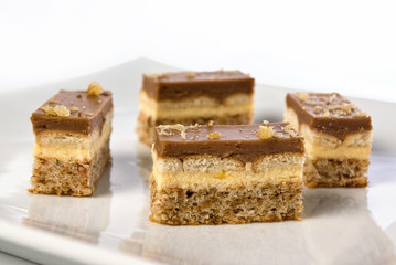 pieces of a chocolate and vanilla pudding cake with walnuts bisc