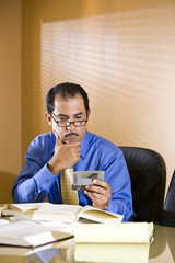 Middle-aged Hispanic businessman texting on mobile phone