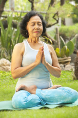 Fototapeta premium Asian senior woman meditating for yoga outside