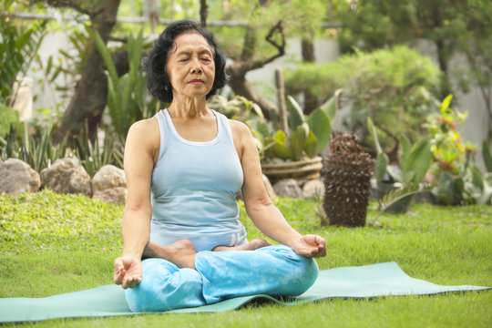 Asian Senior Woman Meditating For Yoga Outside