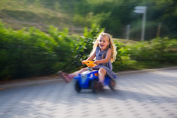 little girl driving with a toy car