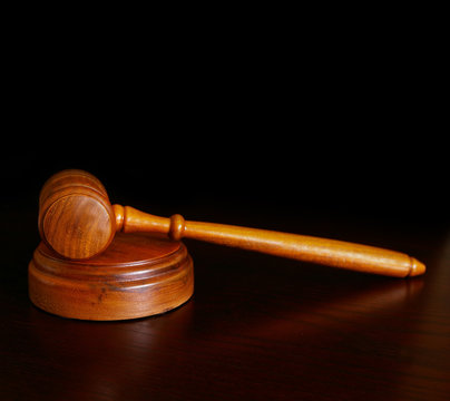 court gavel on desk, over dark background