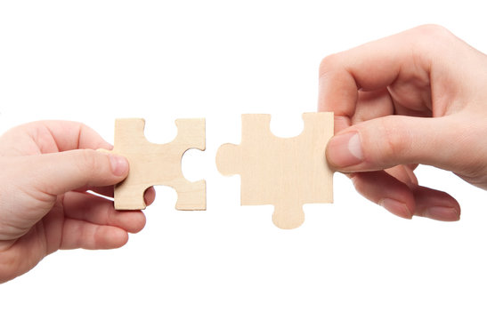 mens and childs hands connecting puzzles