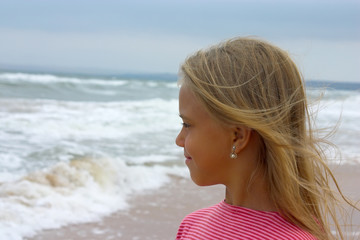 Little girl looking ahead on the beach