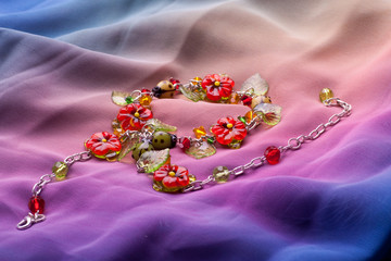 Female bracelet on colored fabrics.